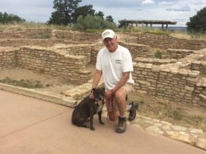 man and dog posing near ruins